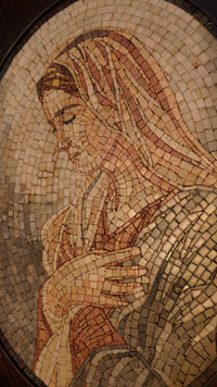 Intricate mosaic artwork depicting a serene figure with delicate facial features and warm earth tones — a timeless representation of craftsmanship.