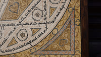 Intricate mosaic art featuring geometric patterns in warm earth tones with detailed inscriptions and textures.