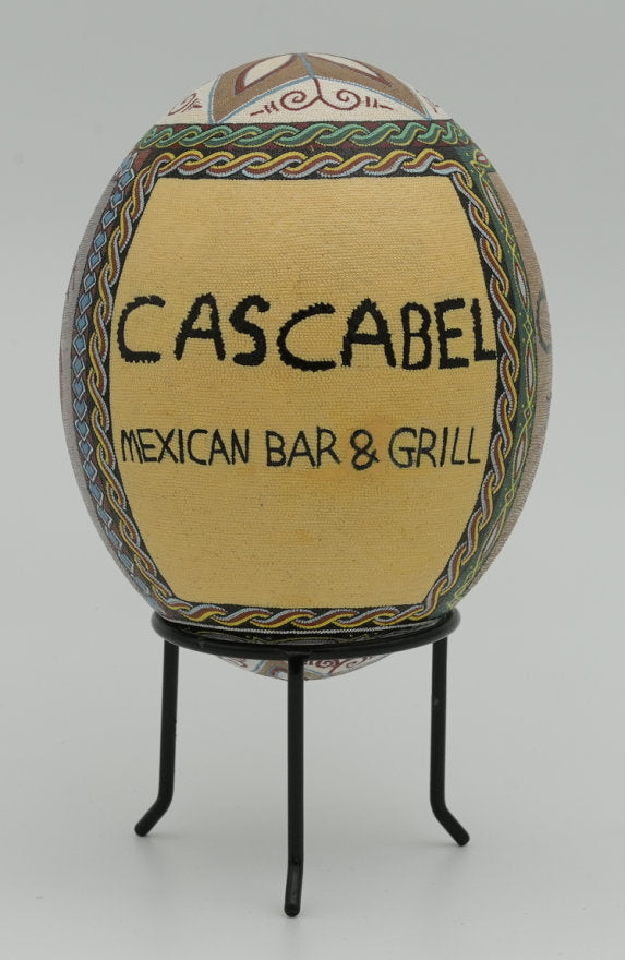 Decorative ceramic egg featuring intricate designs and vibrant colors, displaying the name 'Cascabel Mexican Bar & Grill'