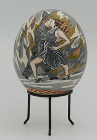 Intricately decorated decorative egg featuring a couple dancing, with vibrant colors and detailed embroidery on a textured surface.