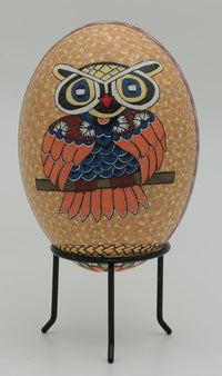 Colorful decorative egg featuring a detailed owl design with intricate patterns on a textured background — vibrant artistry displayed on a stand
