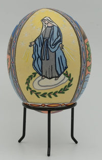 Intricately decorated egg featuring a serene depiction of a figure surrounded by vibrant floral patterns — a unique artistic piece.