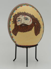 Intricately designed decorative egg featuring a painted image of a bearded figure with a colorful border on a light background