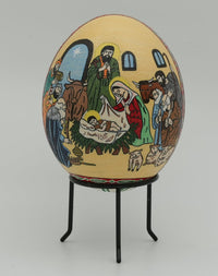 Hand-painted decorative egg featuring a nativity scene — vibrant colors and intricate details on a smooth surface