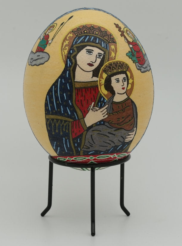 Intricate decorative egg featuring a detailed depiction of the Virgin Mary holding baby Jesus, set on a black metal stand.