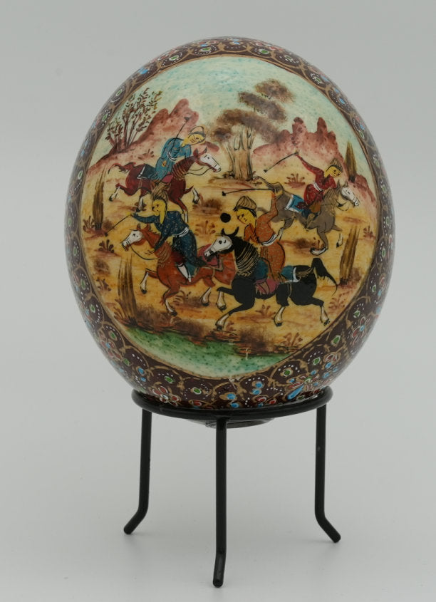Intricately painted decorative egg featuring vibrant horse riders on a scenic background — a unique piece of art on a metal stand