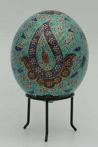 Intricately designed decorative egg with vibrant turquoise and gold patterns — a stunning display of traditional craftsmanship.