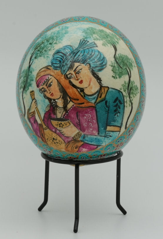 Hand-painted decorative egg featuring two women in traditional attire, with intricate designs and vibrant colors on a smooth surface.