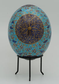 Intricately designed decorative egg featuring a vibrant blue base with gold and purple floral patterns — an artistic home accent