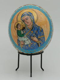 Intricately painted decorative egg featuring a blue-clad Virgin Mary holding baby Jesus, set against a soft grey background.