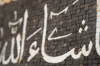 Intricate mosaic artwork featuring Arabic calligraphy in contrasting black and white tiles — a stunning display of craftsmanship.