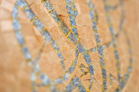 Intricate mosaic art piece featuring shimmering blue tiles set against a warm, textured background — an elegant display of craftsmanship.