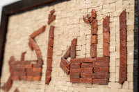 Intricate mosaic artwork featuring Arabic calligraphy crafted from natural stone tiles — rich textures in earthy tones.