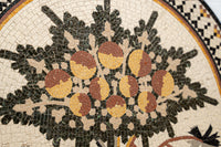 Intricate mosaic art featuring a floral design with earthy tones of brown, yellow, and green — crafted with detailed tile work