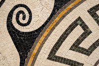 Intricate marble mosaic featuring swirling black and cream patterns with golden accents — a stunning blend of artistry and craftsmanship.
