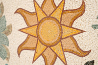 Intricate mosaic sun design with warm yellow and brown hues, showcasing detailed craftsmanship in a textured tile pattern.