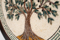 Intricate mosaic wall art featuring a tree design with green leaves and brown trunk, set against a textured cream background.