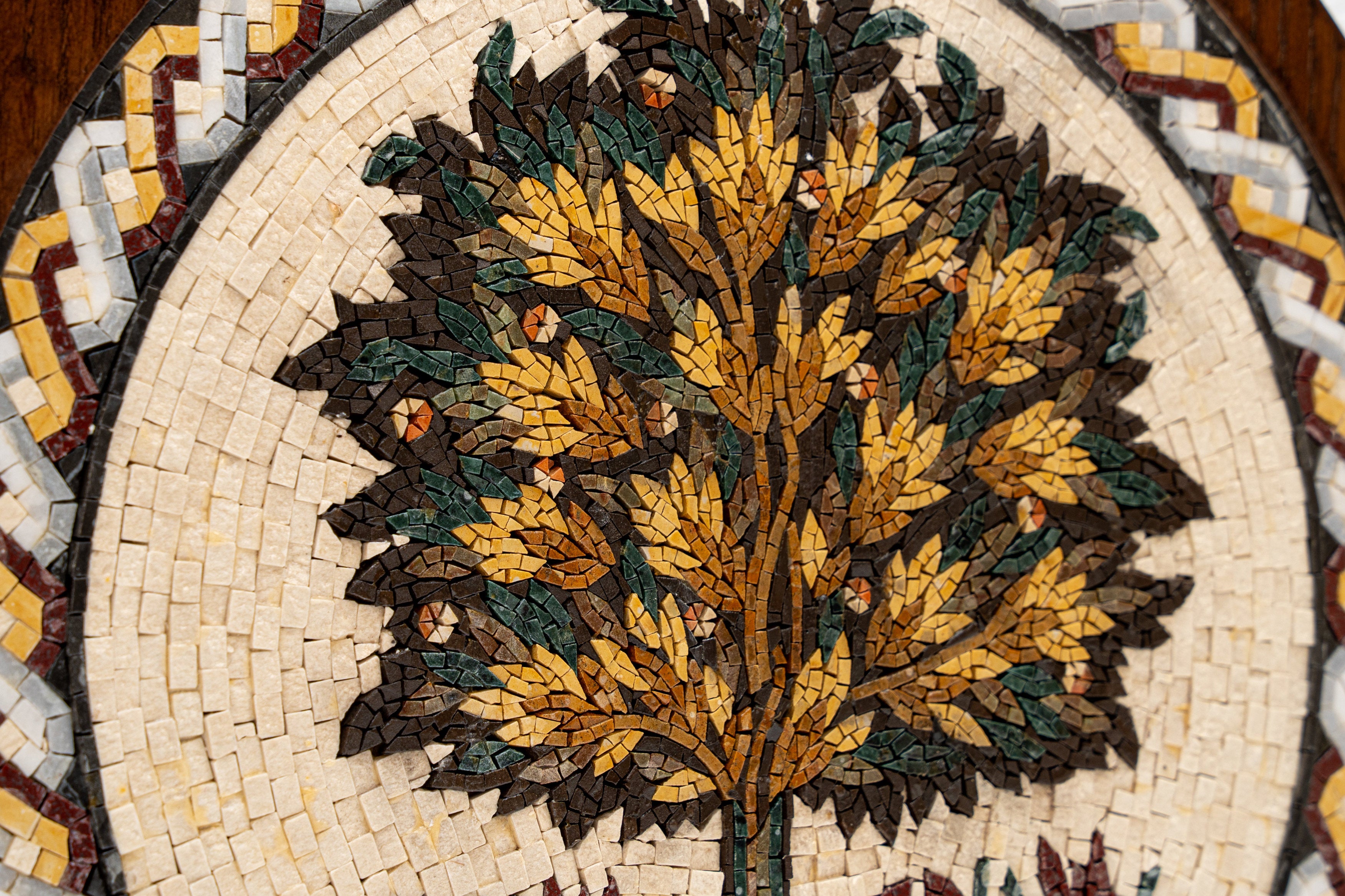 Intricate mosaic art featuring a vibrant tree design with golden leaves and earthy brown accents on a cream background