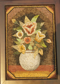 Intricate mosaic artwork featuring a vase of colorful flowers — crafted from natural stone tiles with a textured finish.