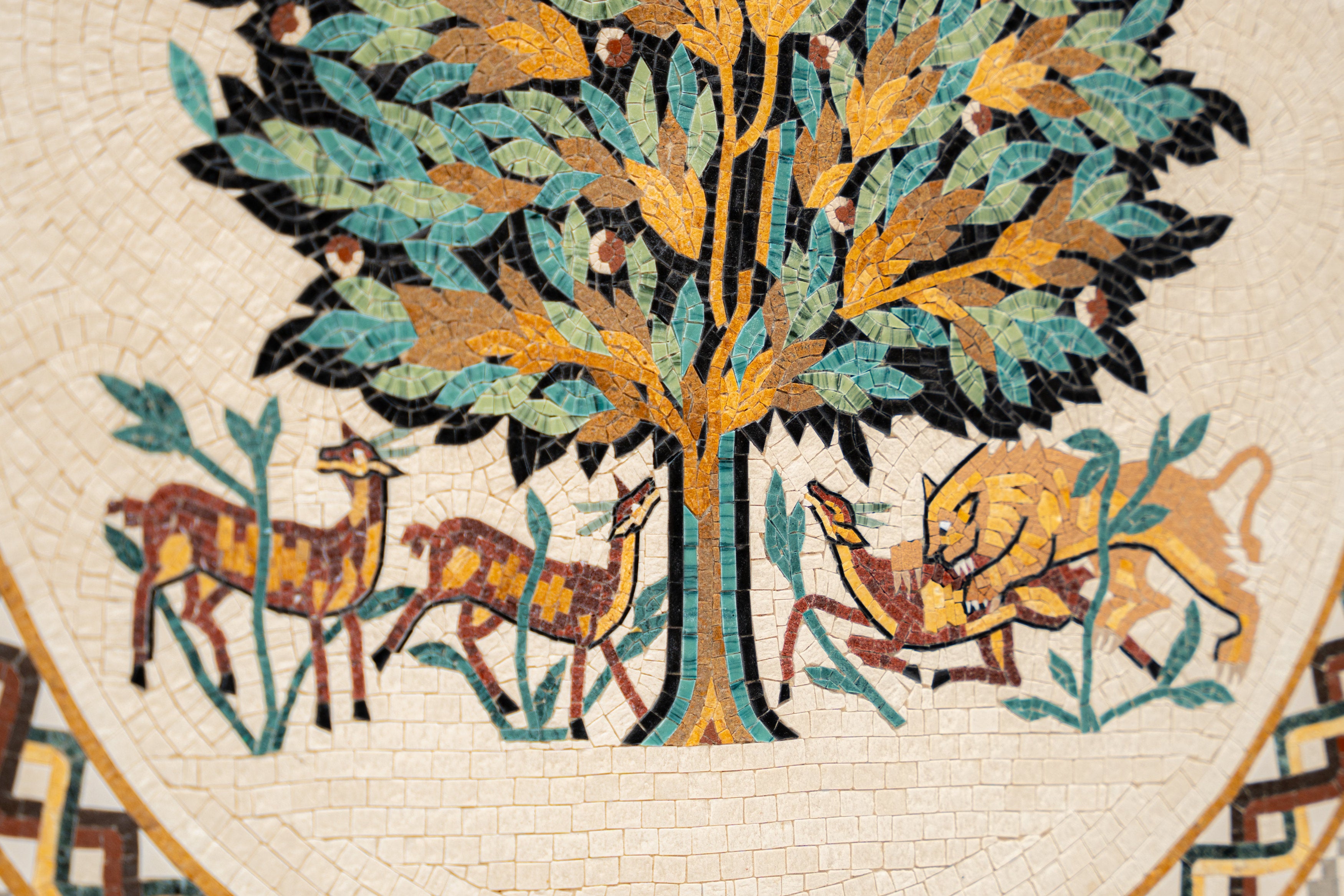 Intricate mosaic artwork featuring a tree and animals in warm hues — a vibrant depiction of nature's harmony.
