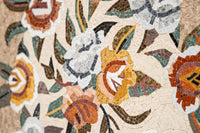 Intricate mosaic wall art featuring vibrant flowers in orange, white, and green tones — a stunning decorative piece.