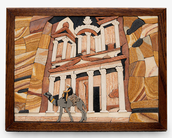Intricate mosaic artwork depicting a camel and rider in front of ancient architecture — crafted with natural stone textures.