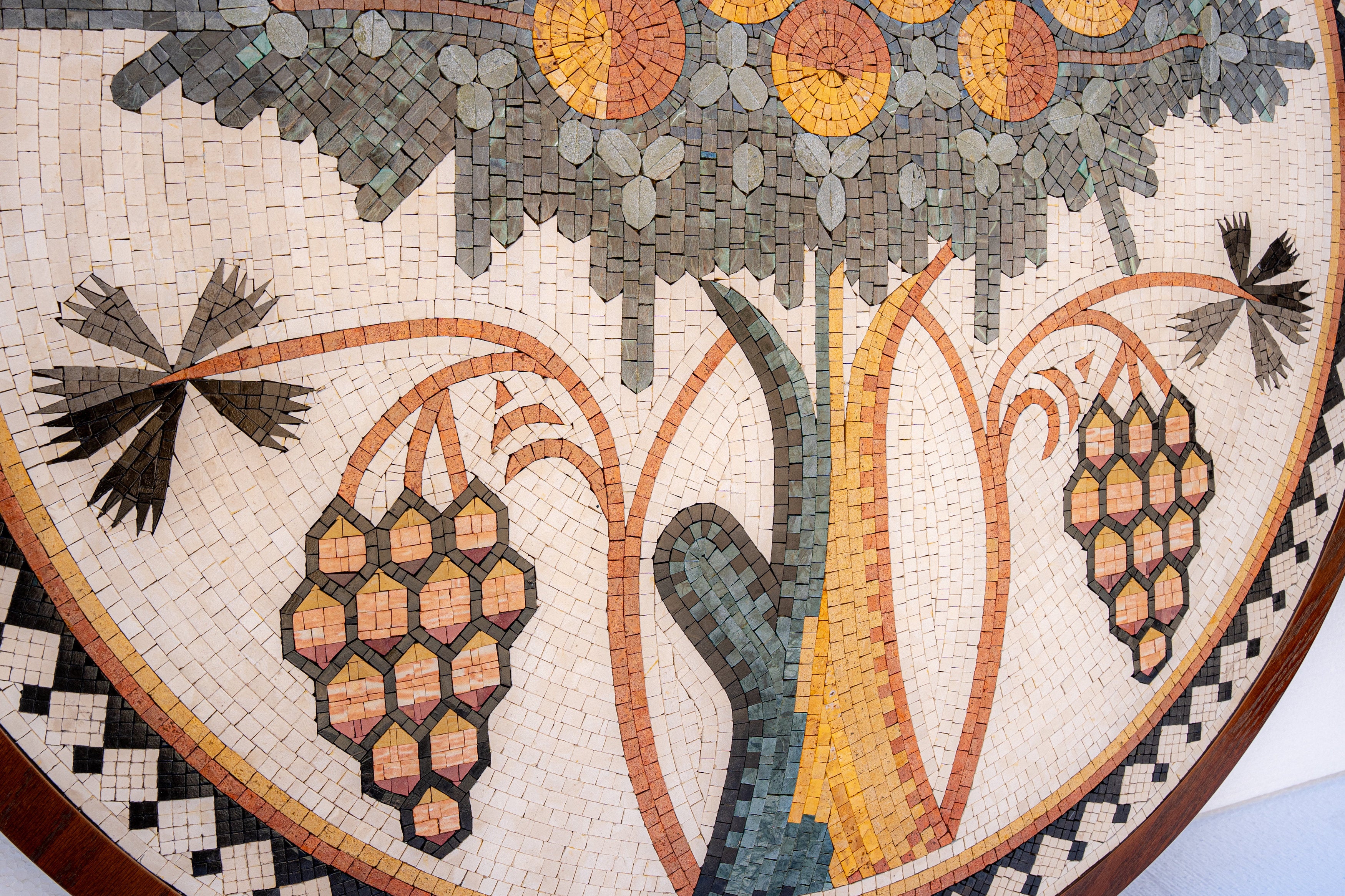 Intricate mosaic artwork featuring floral and fruit designs in earthy tones — a blend of natural textures and craftsmanship.