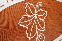 Intricate mosaic tile featuring a leaf design in earthy terracotta with contrasting white detailing, showcasing craftsmanship.