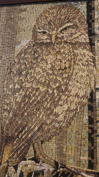 Intricate mosaic art featuring a detailed brown owl with textured feathers and a serene expression against a neutral background