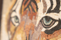 Intricate mosaic art featuring a close-up of a tiger's eye in earthy tones with textured ceramic tiles.