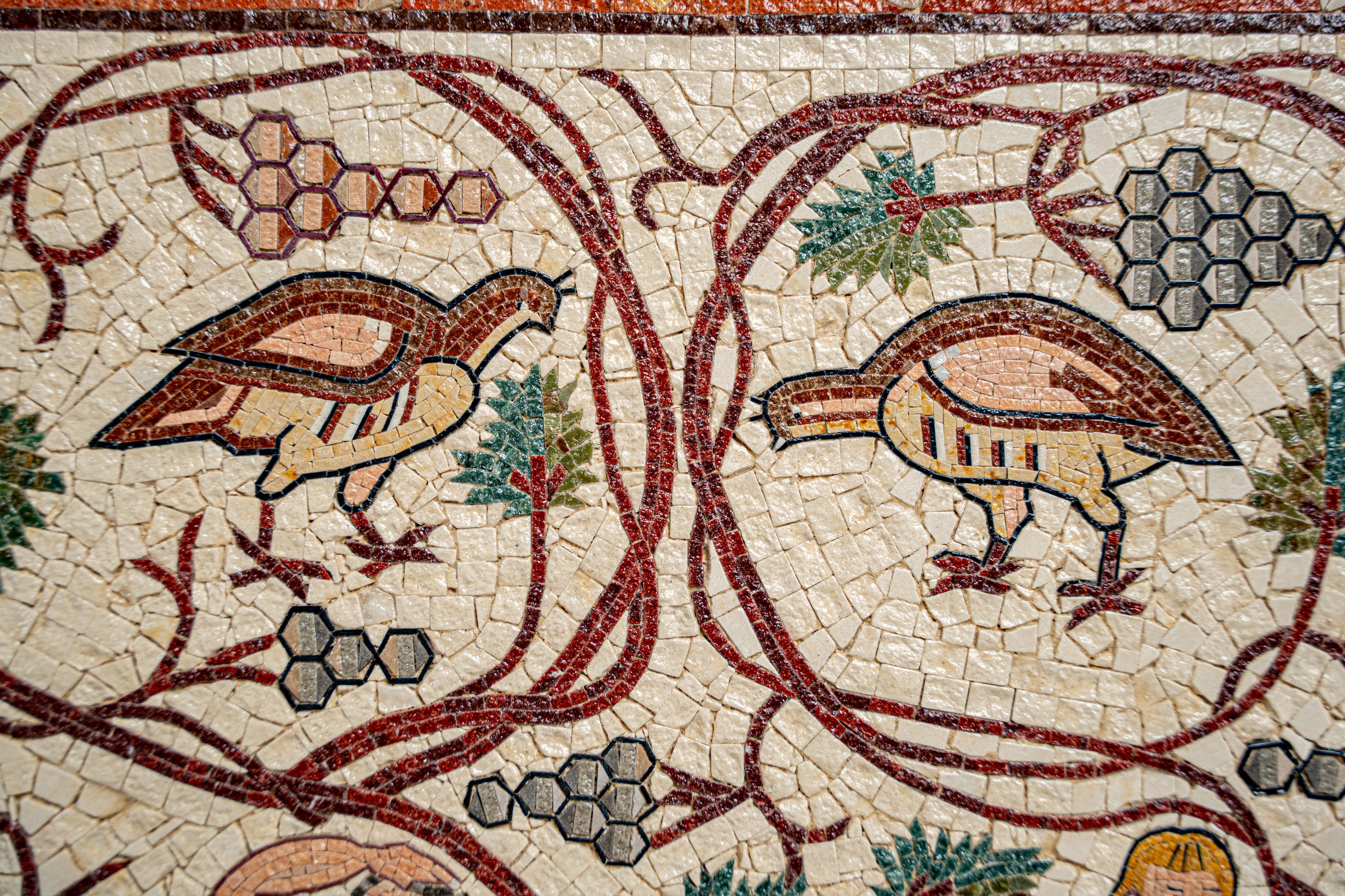 Intricate mosaic art featuring stylized birds and floral motifs in earthy tones — a stunning depiction of ancient craftsmanship.