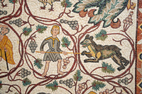 Intricate mosaic artwork depicting a boy wielding a stick beside a wild animal among grapevines — showcasing ancient craftsmanship.