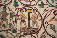 Intricate mosaic artwork depicting two figures standing beside a scale, surrounded by grapevines and detailed patterns.