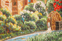 Vibrant mosaic artwork featuring a rustic wheel beside a serene stream, showcasing intricate textures and colors.