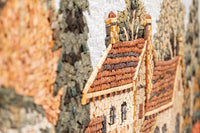 Intricate mosaic wall art depicting rustic houses with earthy tones and textured stone detailing — a charming landscape scene