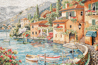 Colorful mosaic artwork depicting a serene lakeside village with vibrant flowers and quaint houses reflecting on the water.