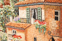 Intricate mosaic artwork featuring a charming house with green shutters and vibrant floral accents — a textured blend of natural stones.