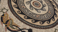 Intricate mosaic flooring featuring a circular design with earthy tones and geometric patterns — a blend of artistry and craftsmanship