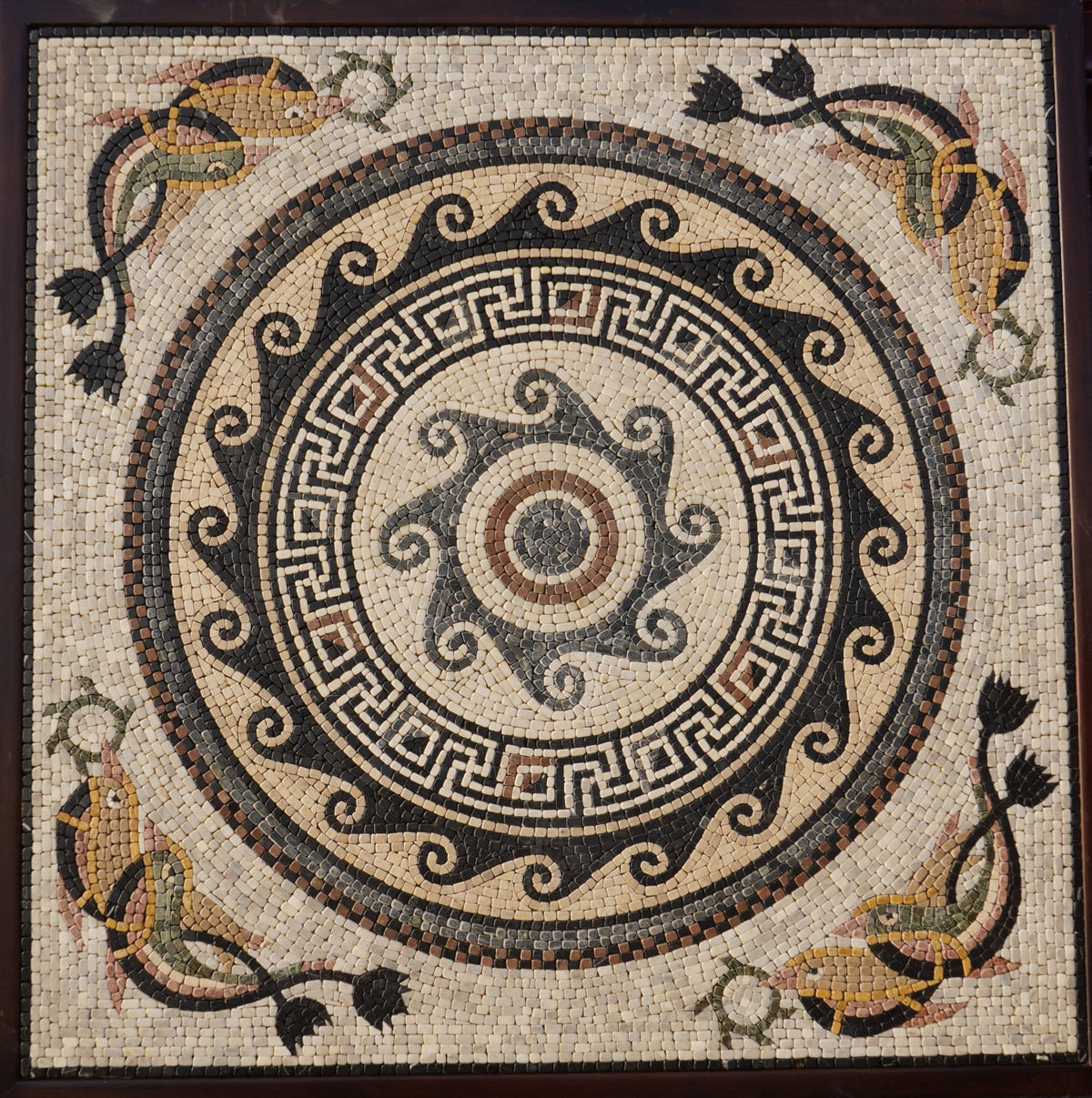 Intricate mosaic art featuring a central spiral design with colorful fish and floral motifs — crafted from natural stone tiles.