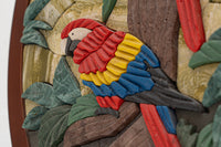 Vividly detailed wooden parrot wall art featuring vibrant red, yellow, and blue colors among textured green leaves