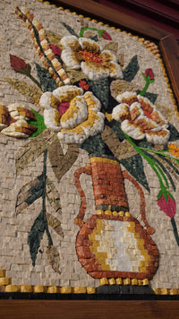Intricate mosaic artwork featuring a vibrant floral arrangement in earthy tones — detailed craftsmanship with a textured finish