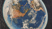 Intricate mosaic artwork depicting a world map with vibrant blue ocean and detailed landmasses in earthy tones