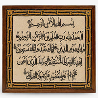 Intricate wooden plaque featuring Arabic calligraphy on a textured background — a decorative piece with cultural significance