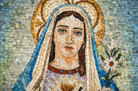 Intricate mosaic art depicting a serene figure with a blue veil and floral detail — vibrant tiles create a textured finish.