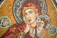 Intricate mosaic art featuring a serene figure with vibrant reds and golds — detailed craftsmanship in each tile.