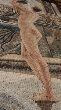Elegant mosaic artwork depicting a nude figure in soft earth tones — intricate tile patterns creating a textured background.