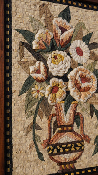 Intricate floral mosaic art featuring a vase adorned with vibrant flowers — crafted from natural stone tiles in warm hues.