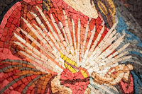 Intricate mosaic art featuring vibrant red and gold tiles — a stunning depiction of light radiating from a central figure.