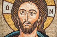 Intricate mosaic artwork depicting a serene face with a golden halo — detailed craftsmanship in earthy tones and textures.