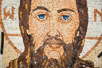 Intricate mosaic portrait featuring a man with striking blue eyes and a detailed beard, crafted from natural stone tiles.